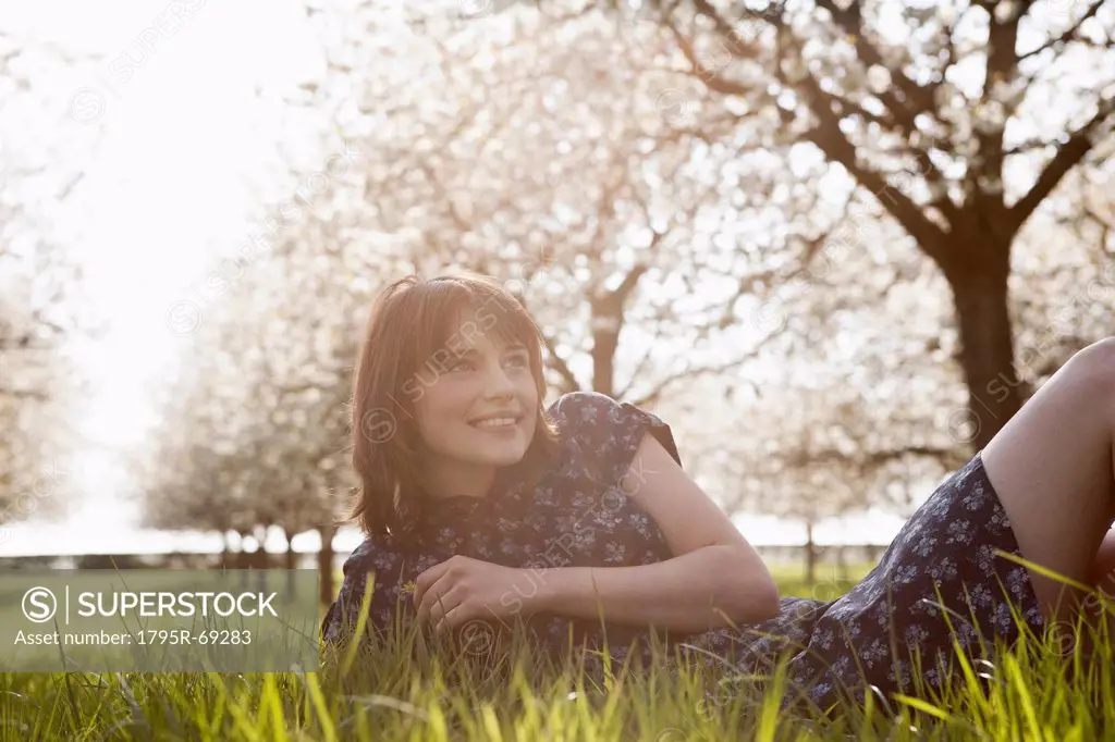 Belgium, Sint_Truiden, Portrait of young woman in spring orchard