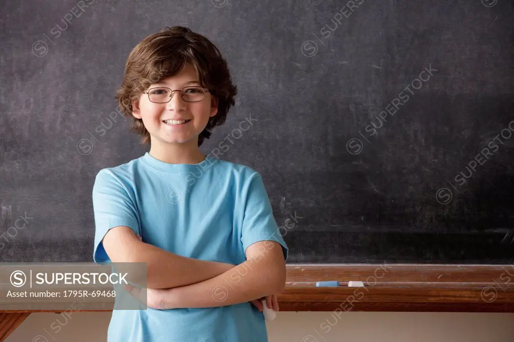 Portrait of schoolboy 10_11 in front of blackboard