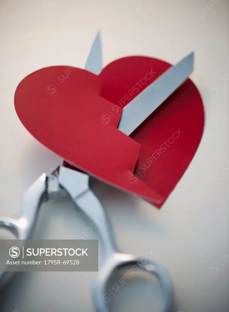 Scissors cutting paper heart