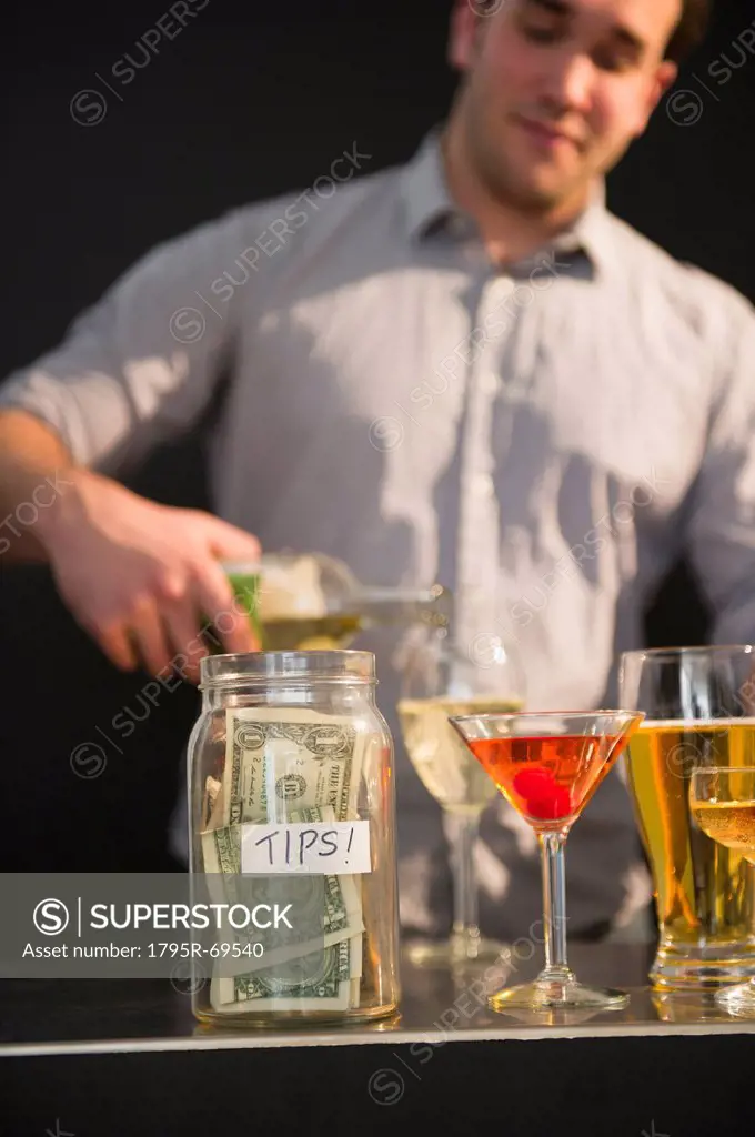 Bar tender pouring wine into glass