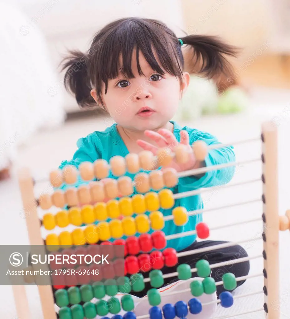 Portrait of baby girl 12_17 months playing with abacus