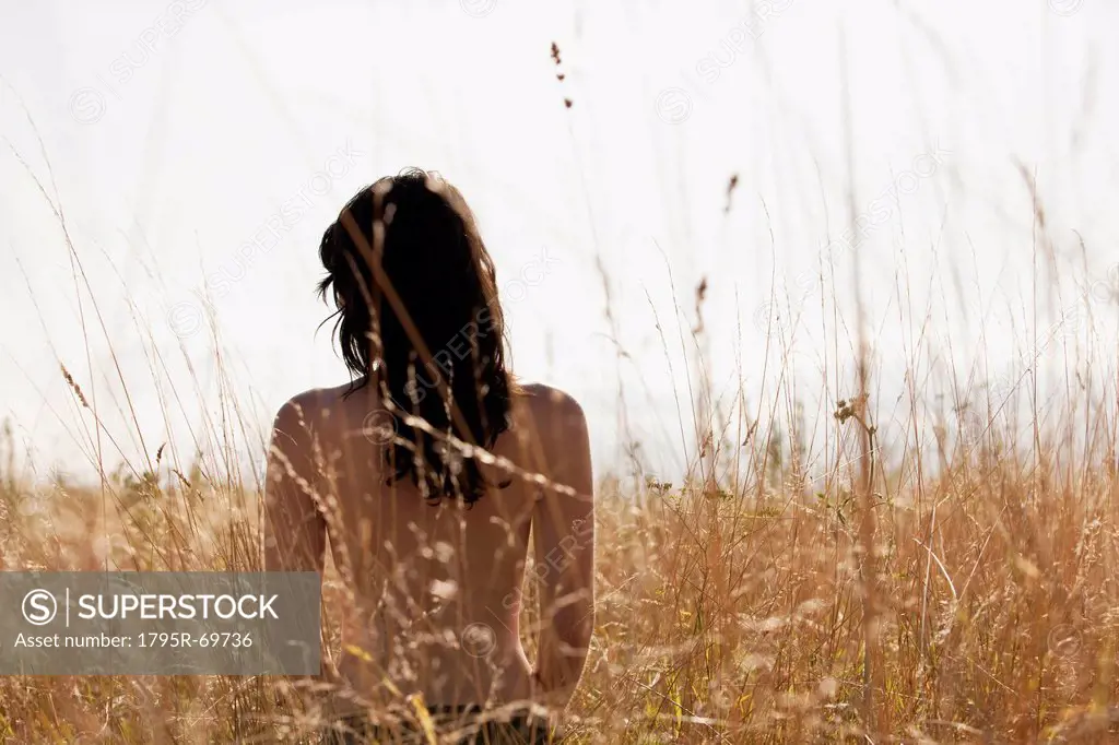 Young woman standing among cornfield