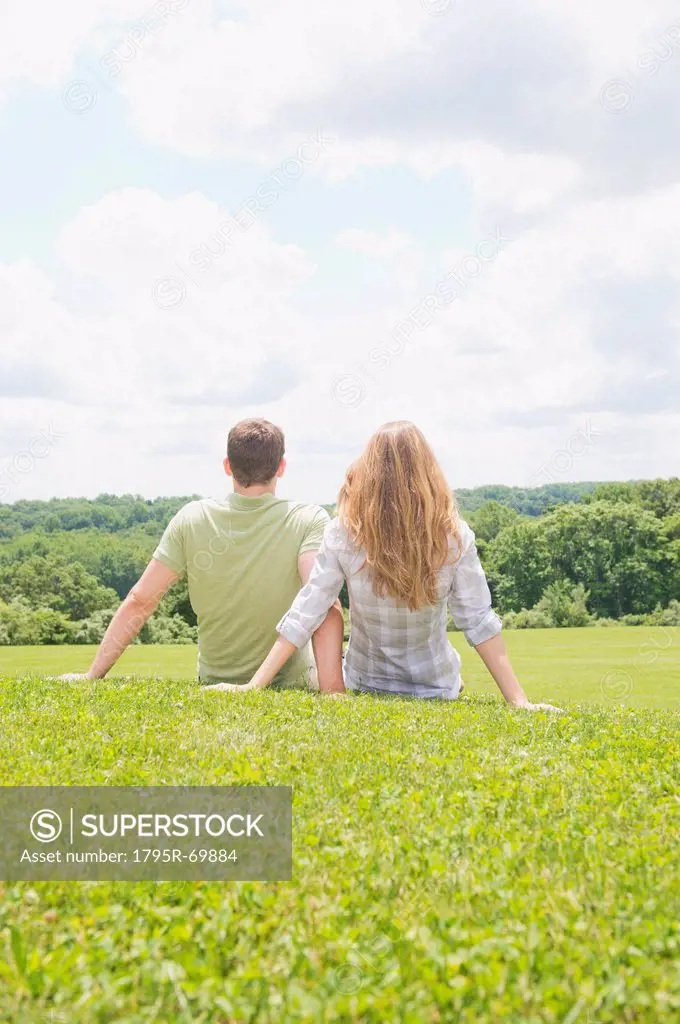 Couple sitting on grass and looking at view