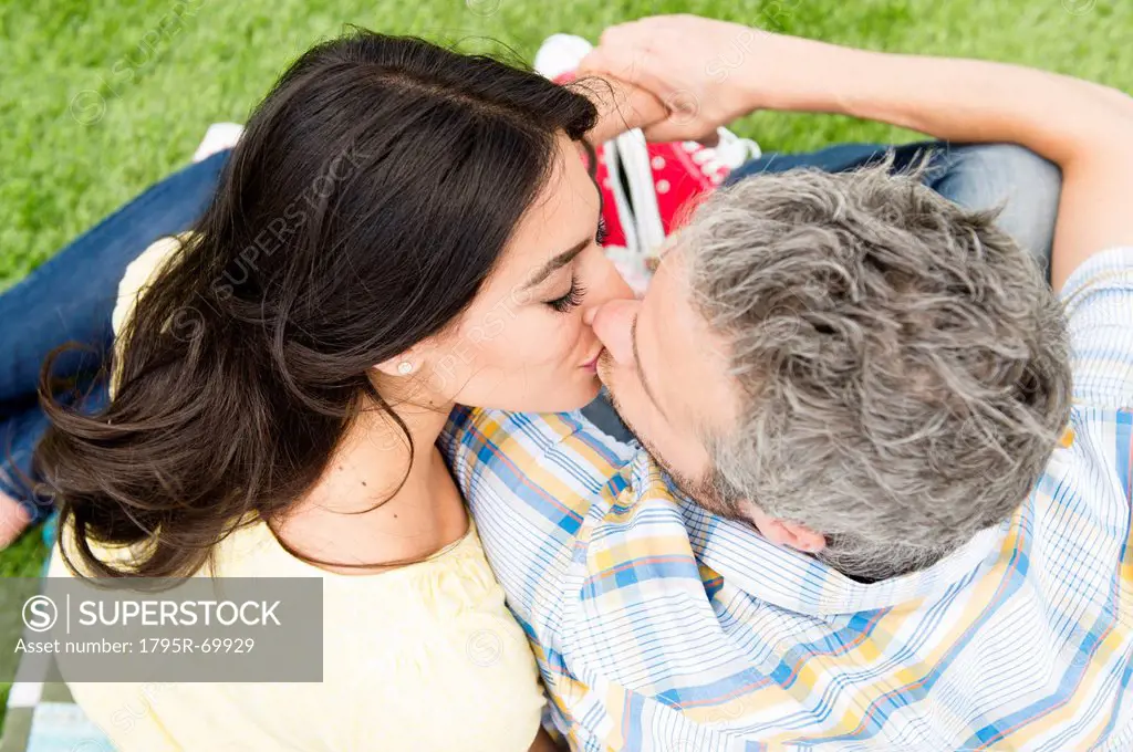 Happy couple kissing on grass