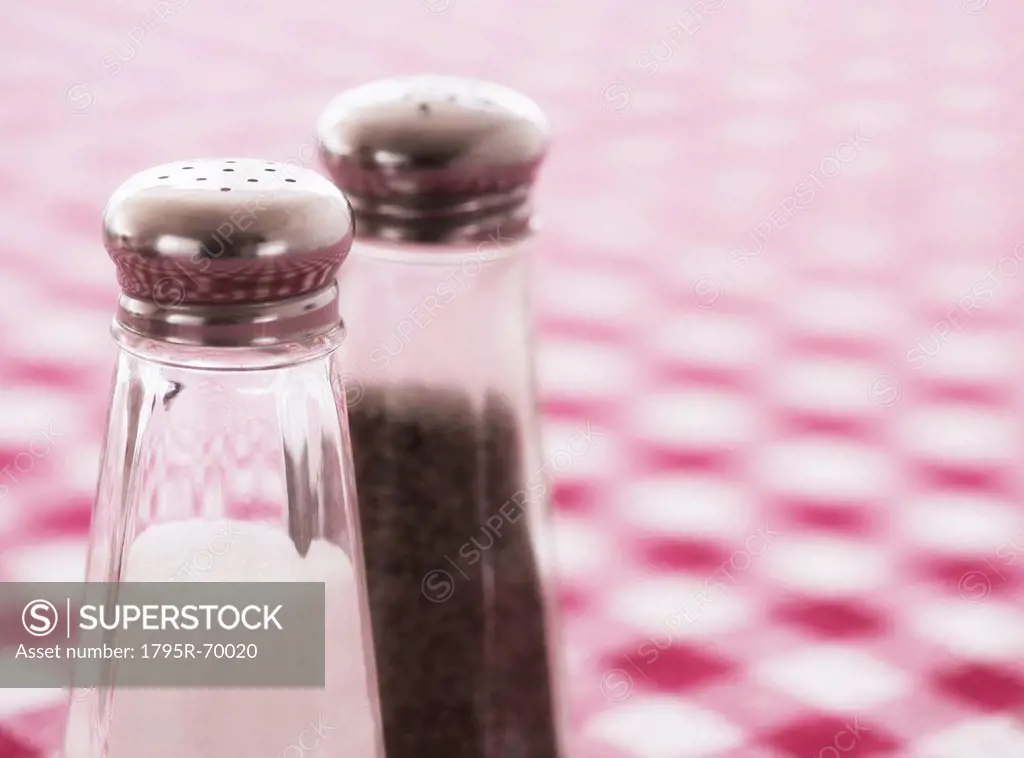 Salt and pepper shakers on checked tablecloth