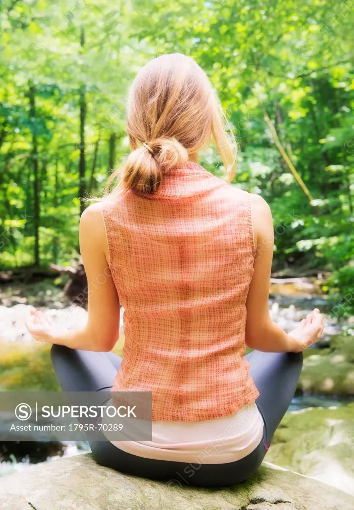 Woman practicing joga in forest