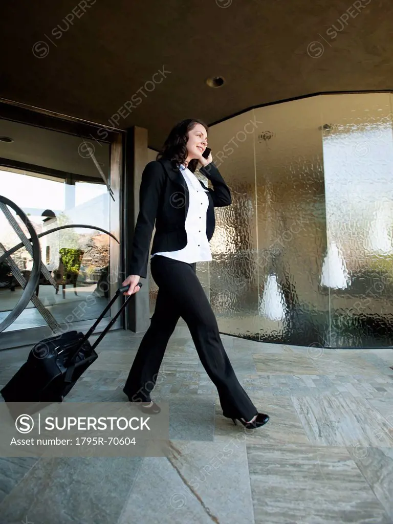 Woman leaving house with piece of luggage