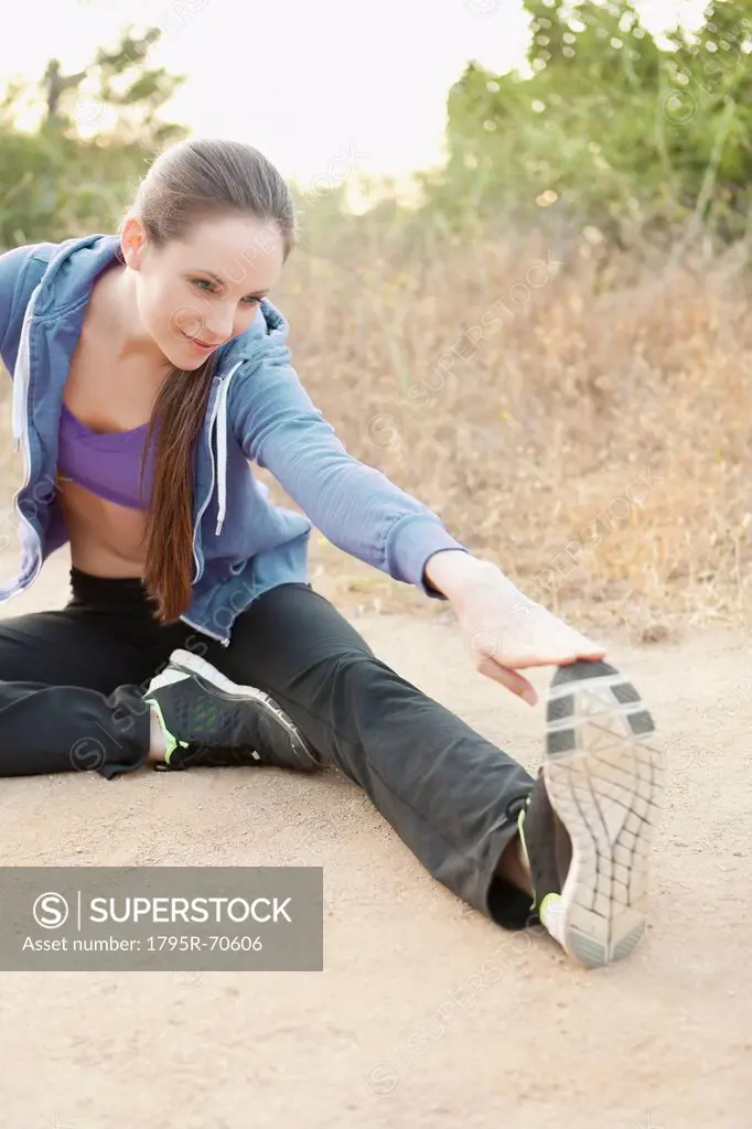 Woman exercising on dusty track