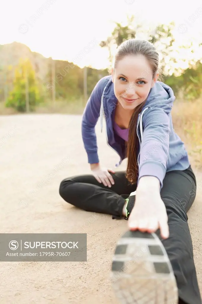 Woman exercising on dusty track