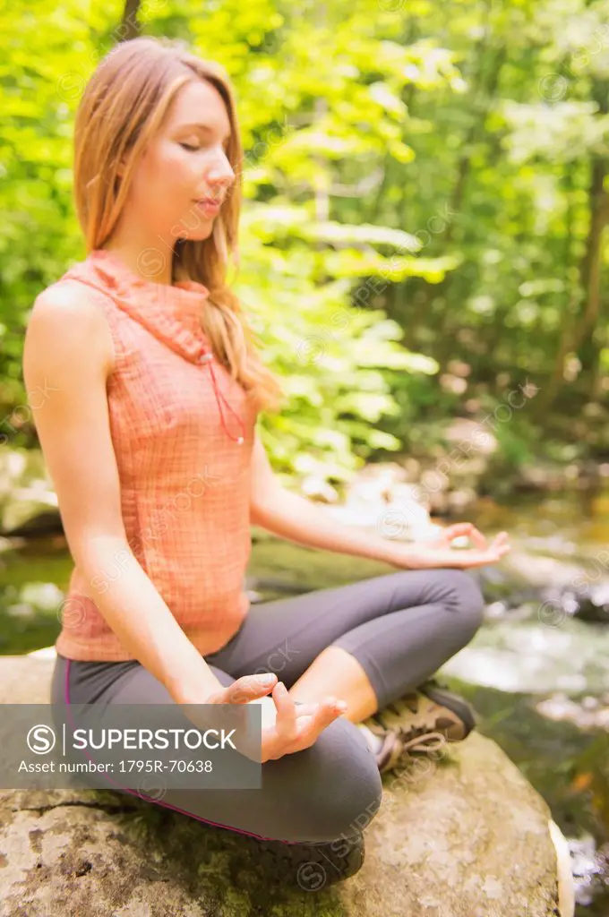 Woman practicing joga in forest