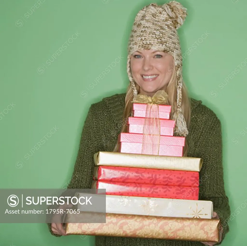 Woman holding stack of Christmas gifts