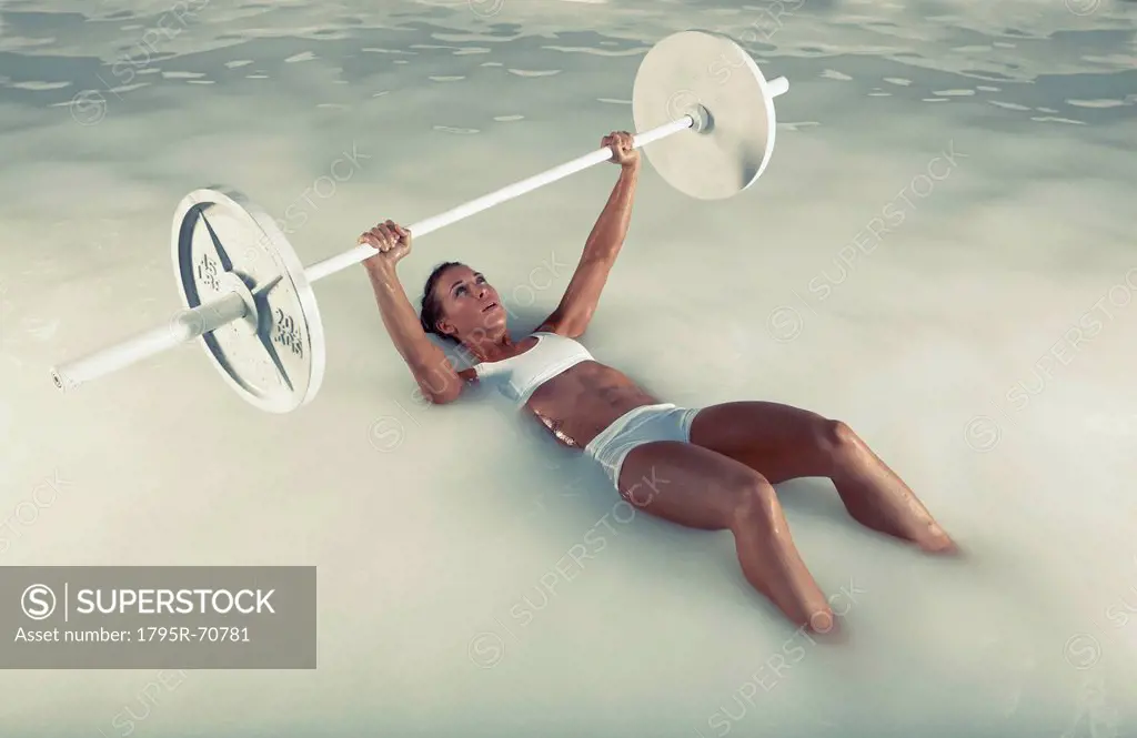 Young woman weight lifting in water