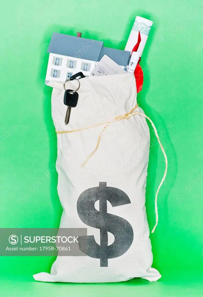 Studio shot of money bag filled with symbols of human expenses