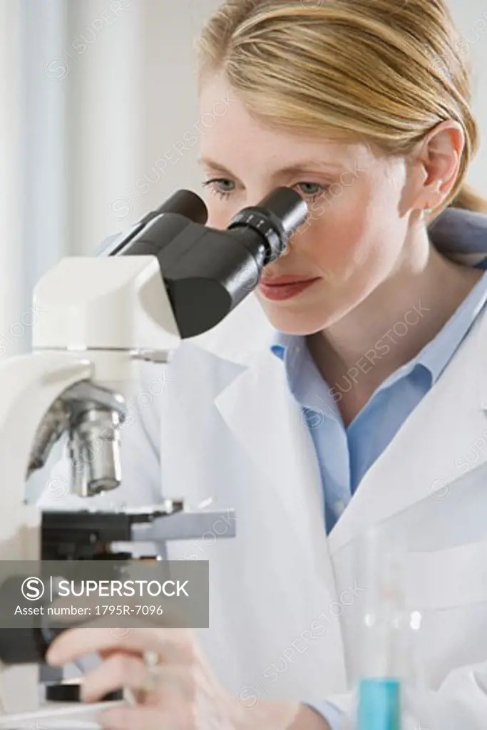 Female scientist looking into microscope