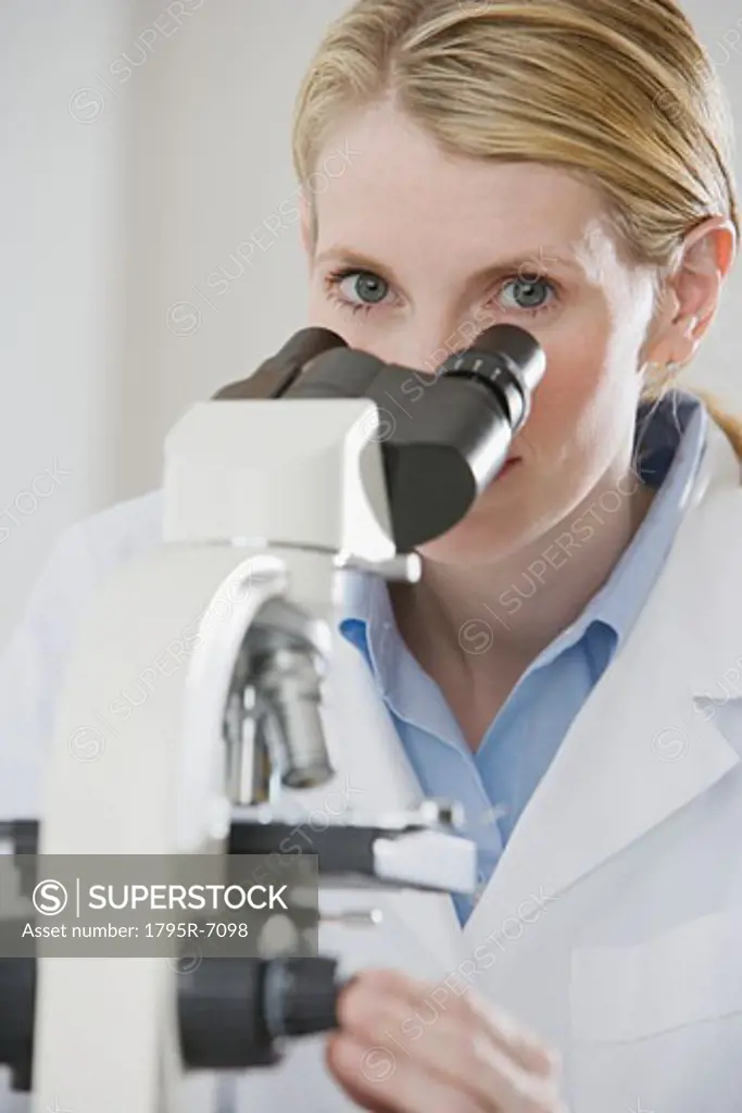 Female scientist looking into microscope