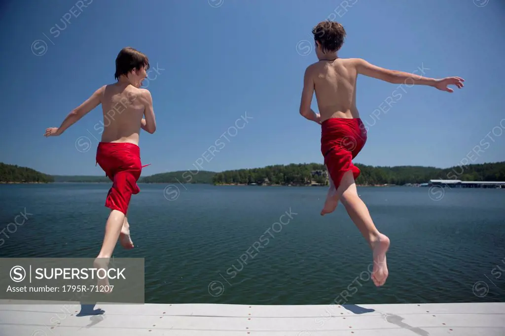 USA, Arkansas, Murfreesboro, Two brothers 8_9, 12_13 jumping into water