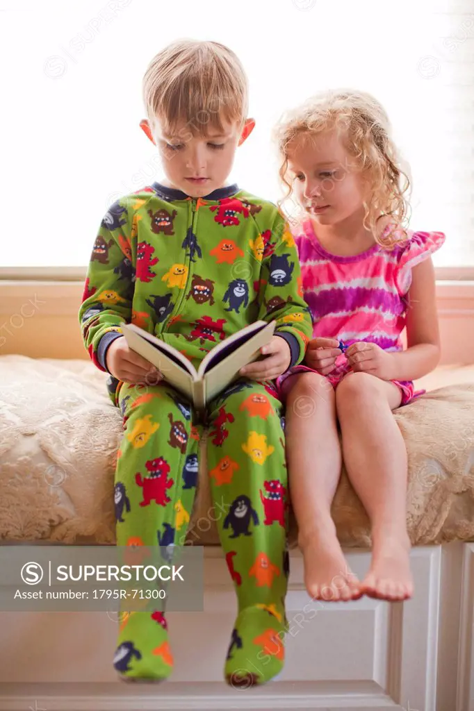 Brother 6_7 and sister 4_5 reading book together