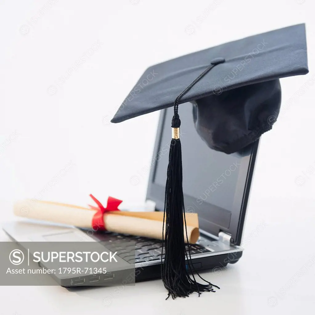 Laptop with diploma and mortar board
