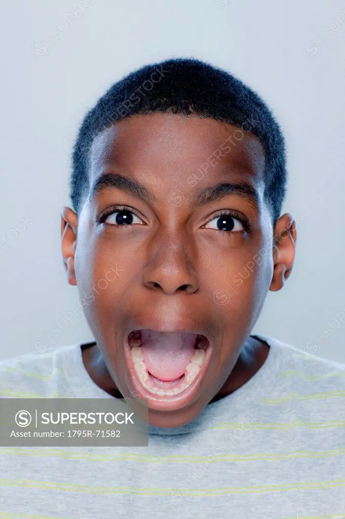 Portrait of teenage boy 14_15 screaming, studio shot