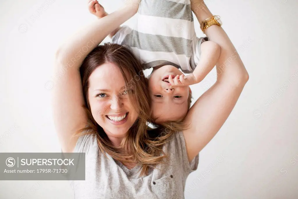 Young woman holding baby boy 6_11 months upside_down