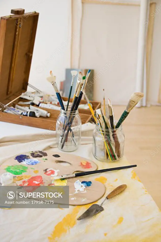 Artist's palette and paintbrushes on table