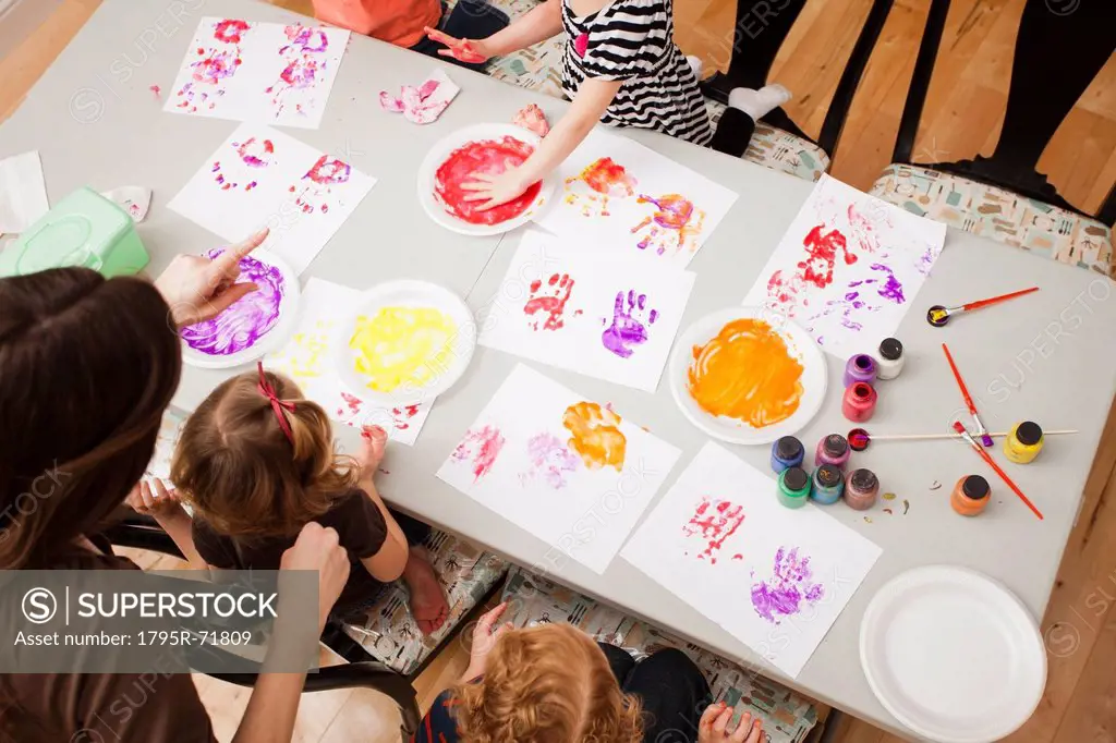 High angle view of children 2_3, 4_5 printing their hands on paper