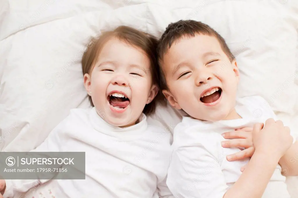 Mixed race siblings 2_3, 4_5 lying in bed side by side