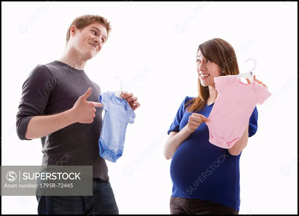 Studio Shot of young couple holding onesie
