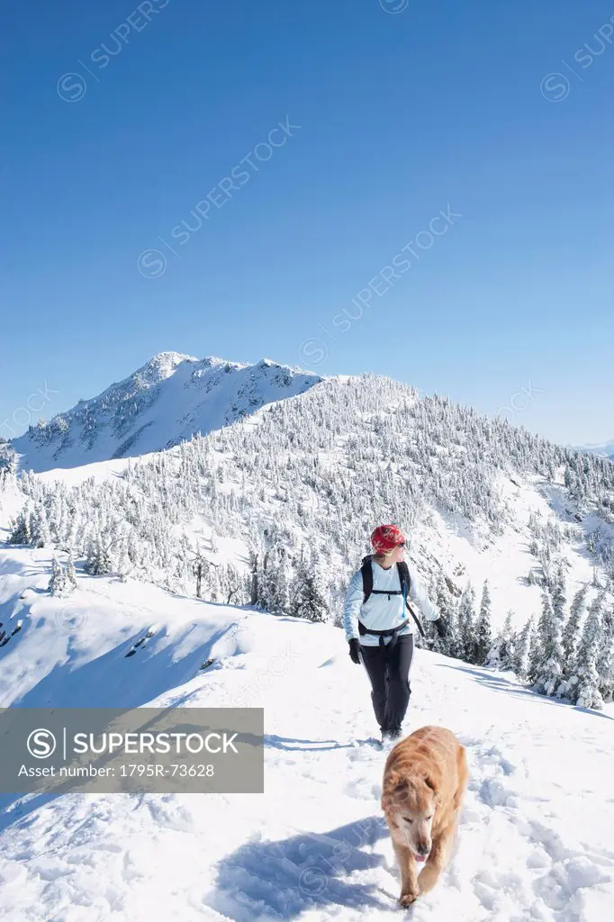 Woman hiking with her dog in winter scenery