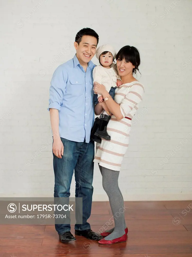 Portrait of young parents with baby girl 12_17 months