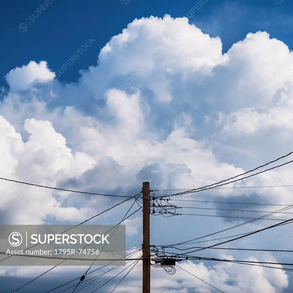 Power lines against cloudy sky