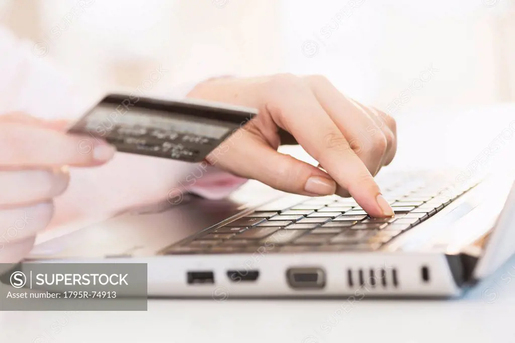 Close up of woman´s hand doing online banking with laptop