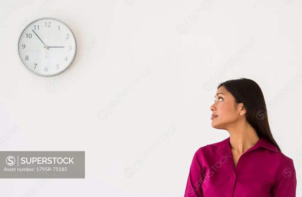 Woman looking at clock on wall
