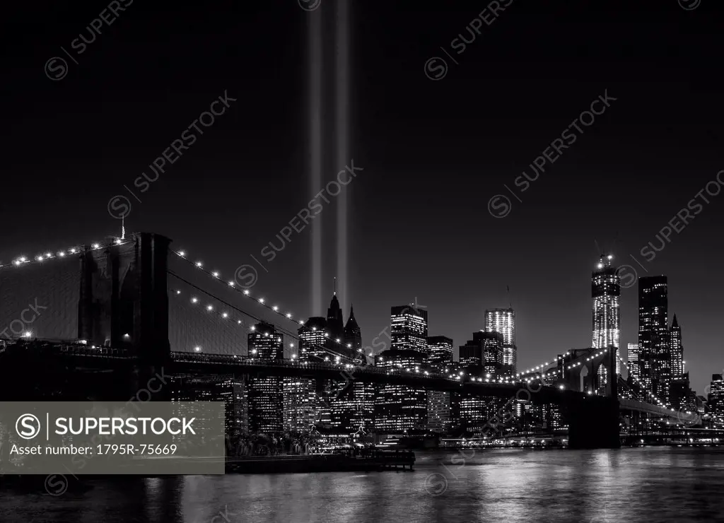 View over Hudson River towards Manhattan with September 11th memorial lights and Brooklyn Bridge