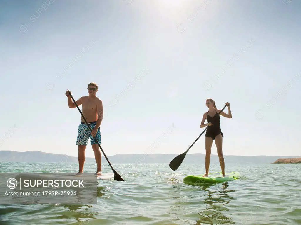 Two people standing on paddleboard