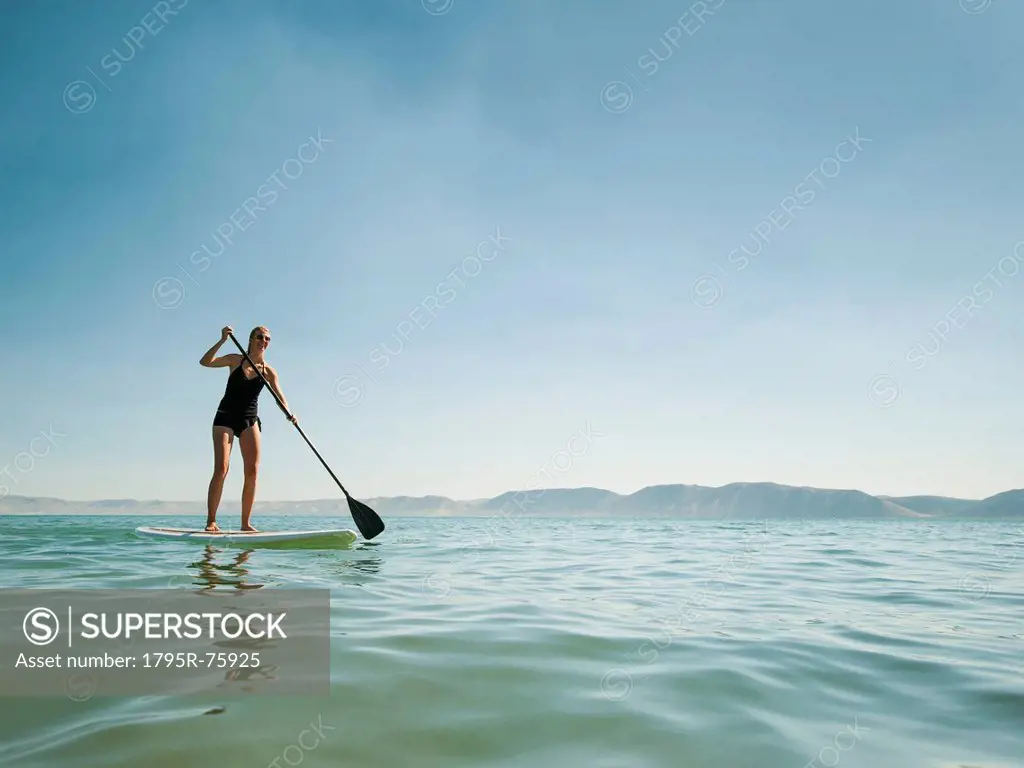 Young woman standing on paddleboard