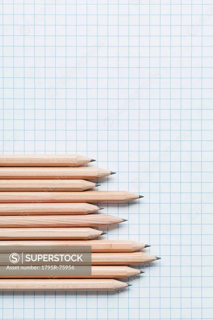 Grouping of wooden pencils in graph shape on graph paper