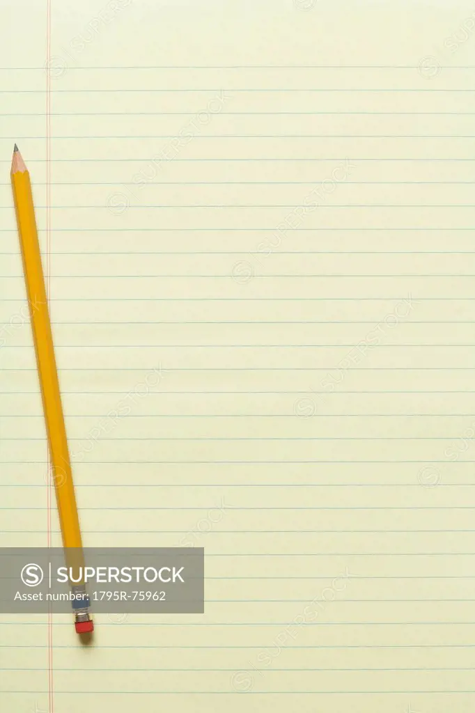 Single yellow sharpened pencil on yellow legal pad