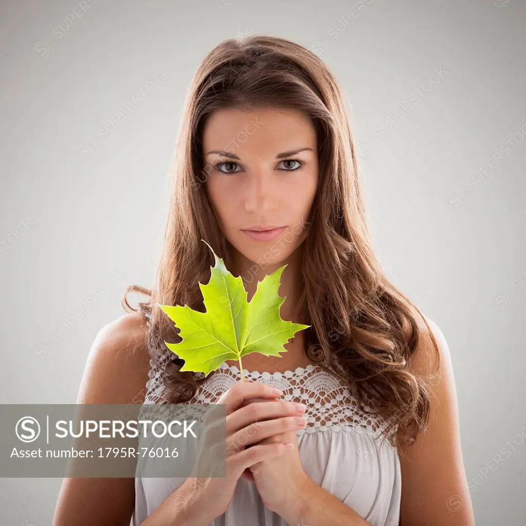 Beautiful woman holding green sycamore leaf