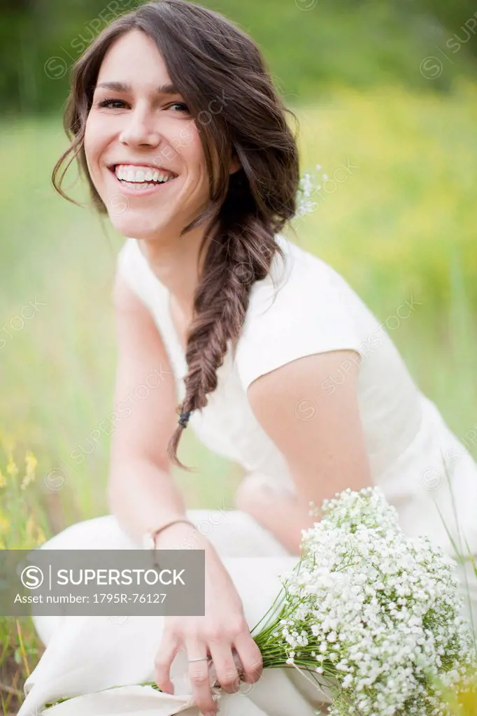 Portrait of young smiling woman holding flowers