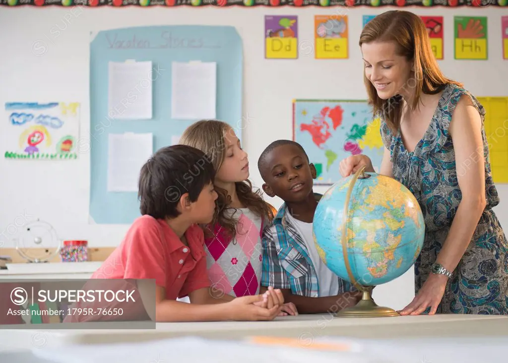 Children 8_9 with female teacher learning in classroom