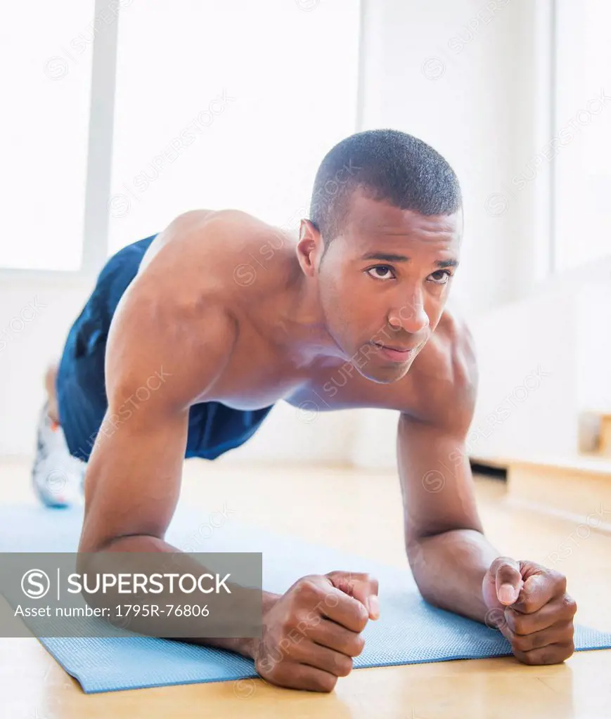 Athletic young man exercising at home