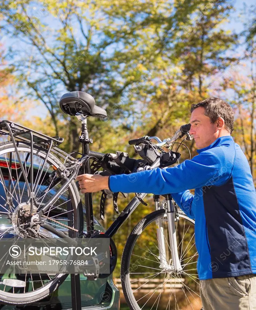 Man putting bicycle onto bike rack