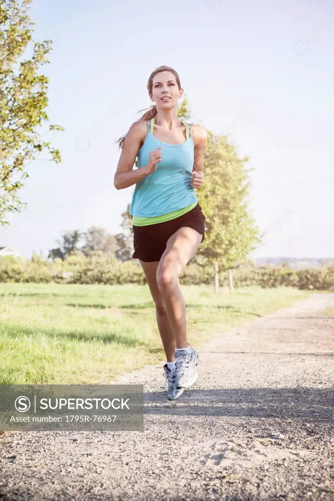 Woman jogging along countryside road