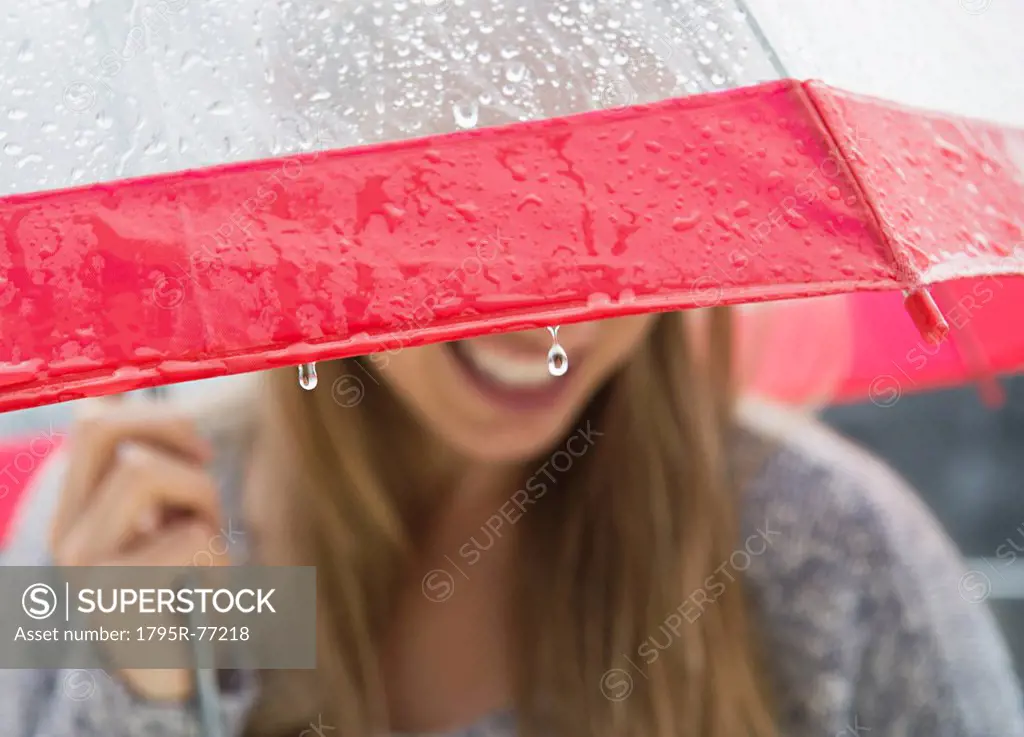 Young woman under umbrella in rain