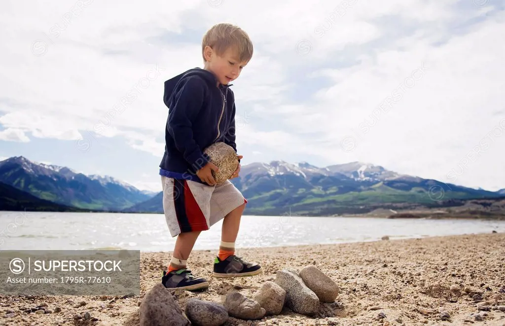 Boy 2_3 carrying rock on beach
