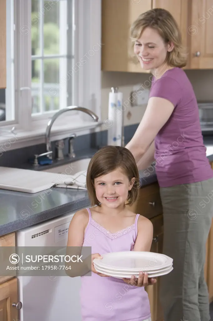 Mother and daughter washing dishes