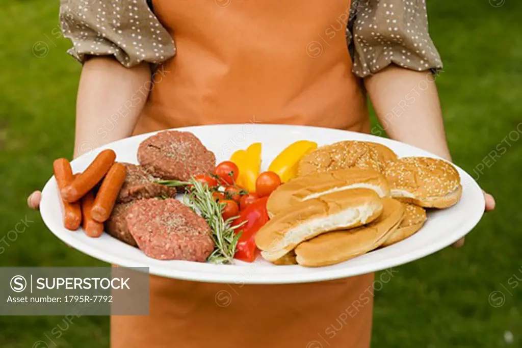 Person holding platter of food for barbeque