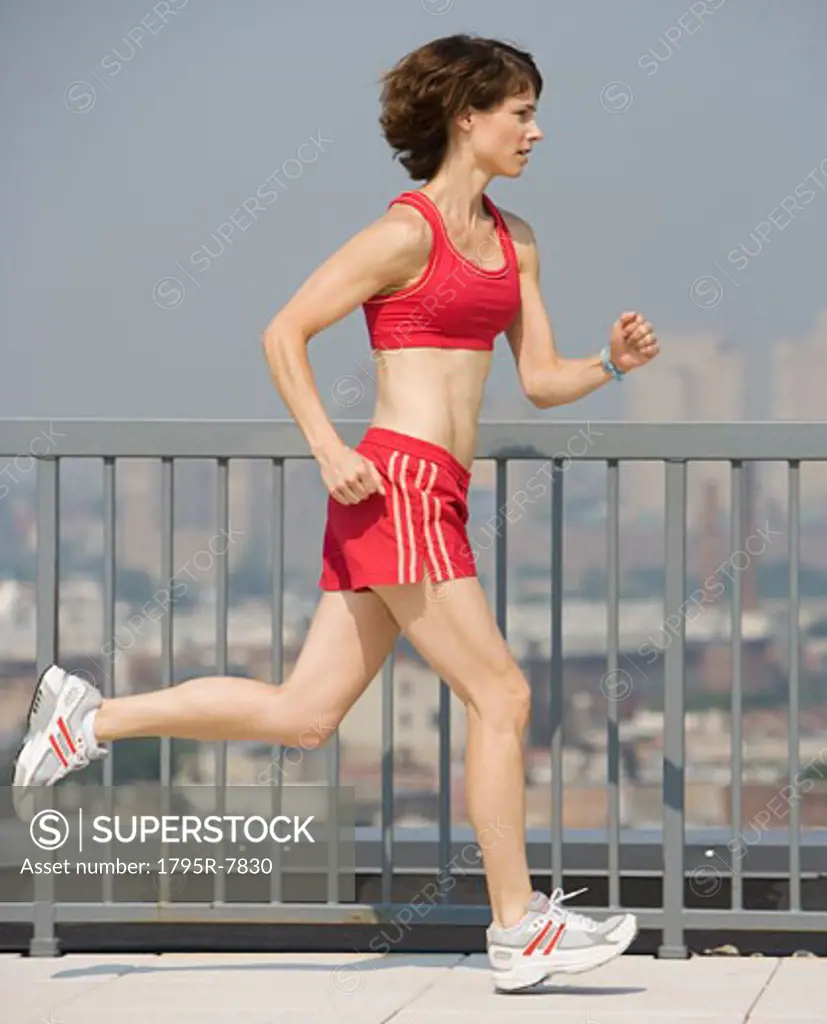 Woman jogging on urban sidewalk