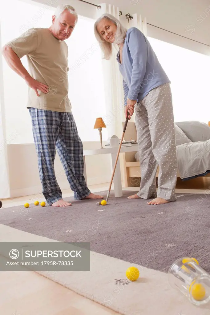 Senior couple playing mini golf at home
